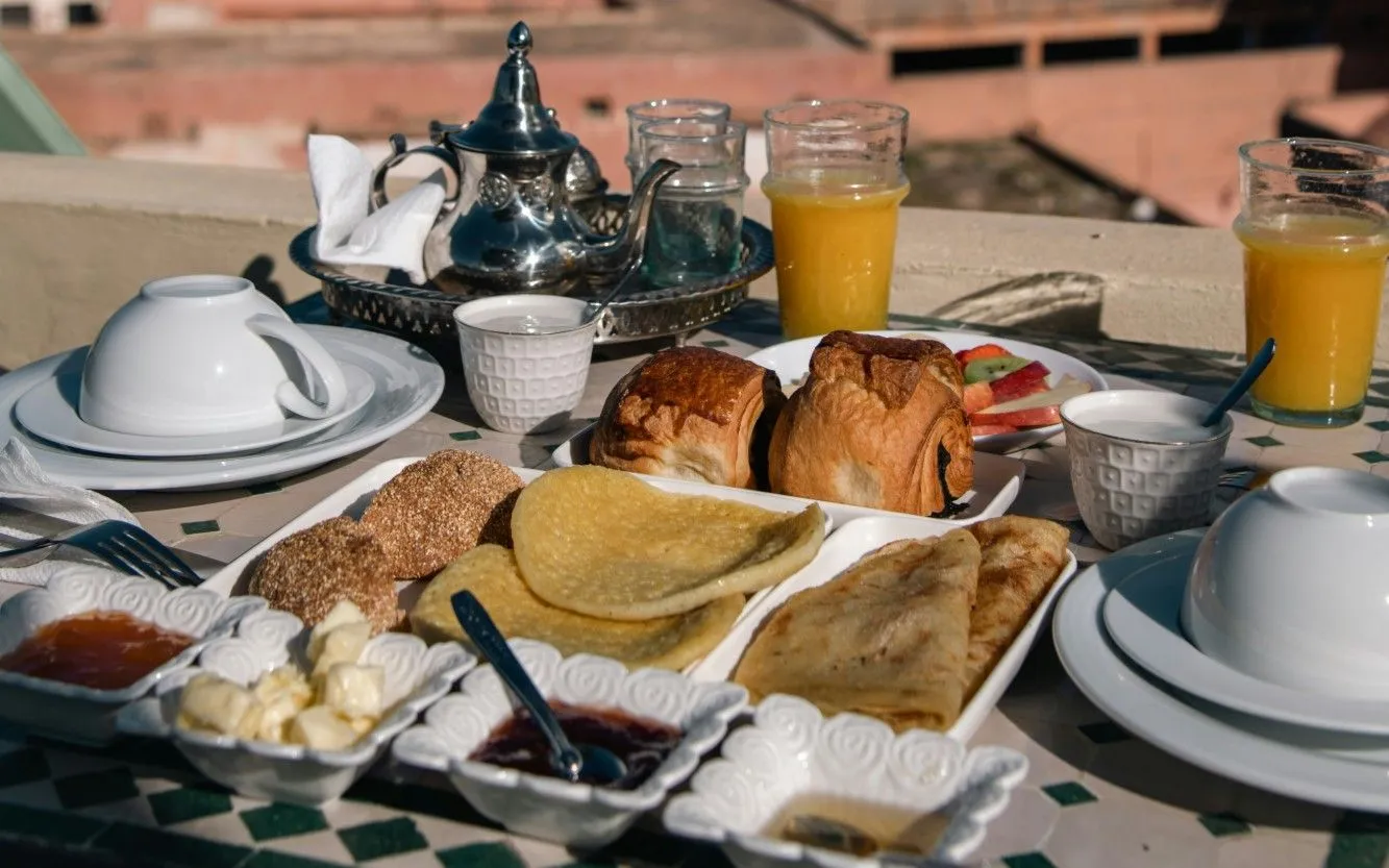 Desayuno marroquí en una terraza, con msemen, pan y té