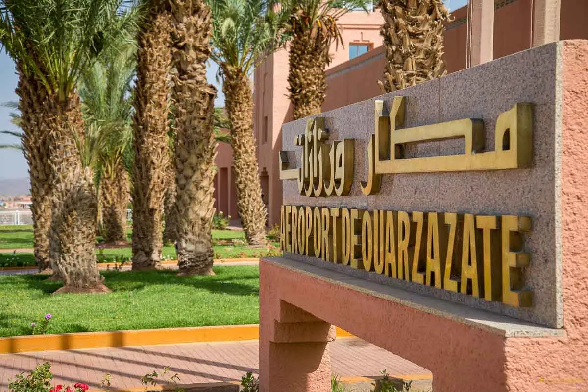 Panneau de l'aéroport de Ouarzazate (OZZ) entouré de palmiers