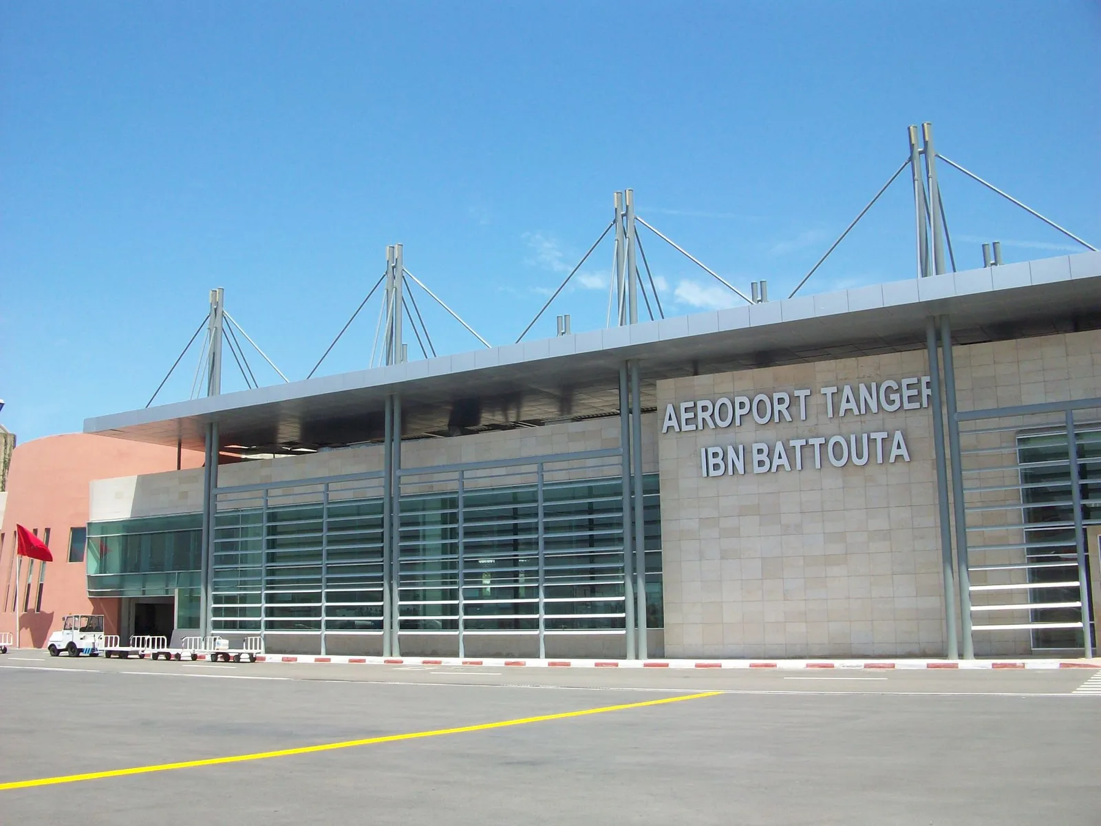 Façade du terminal de l'aéroport Tanger Ibn Battouta sous un ciel bleu
