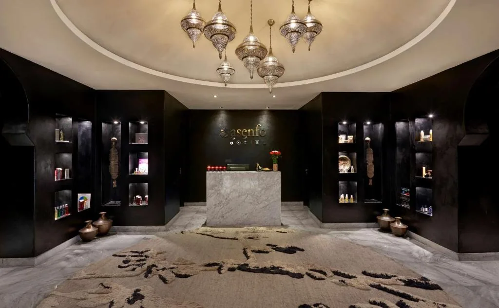 Dark spa reception with lit shelves and hanging lanterns