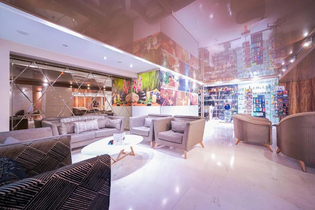 Large lounge with grey sofas, with a ceiling decorated with a colourful mural