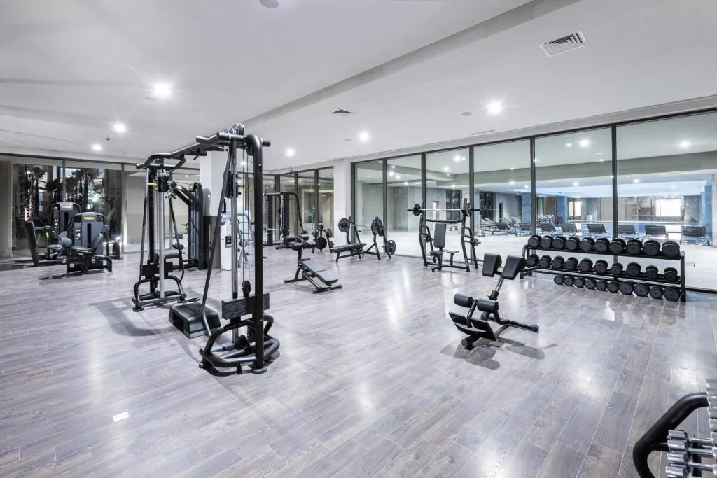 Gym with large picture windows, weight machines and dumbbells lined up