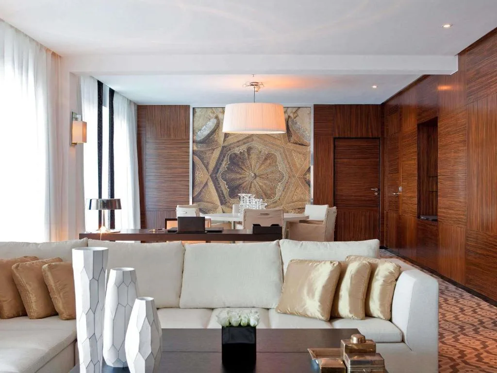 Salon aux boiseries veinées, grand canapé blanc et grand panneau illustrant une coupole ornée
