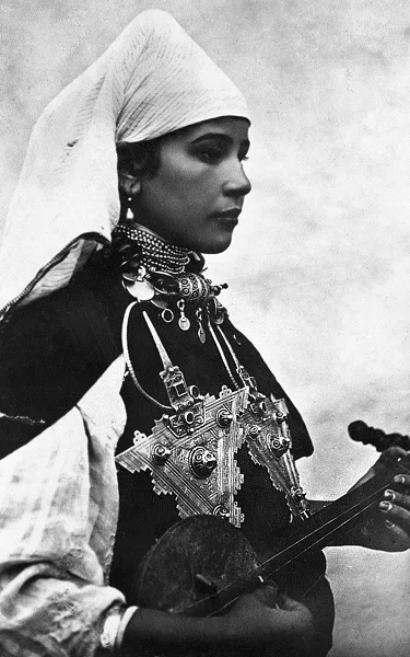 An old black-and-white photograph of an Amazigh woman wearing heavy silver jewellery